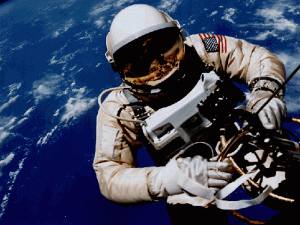 Edward H. White II displays the U.S. flag on his space suit during his historic spacewalk, or EVA (NASA JSC Photograph S65-30431)